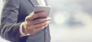 Man in a suit holding a smart phone