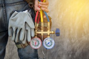 Technician with gauges and gloves in back pocket