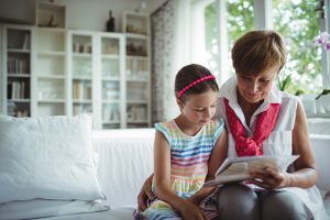 Woman and child reading a book on a couch