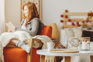 Woman reading a book on an orange chair