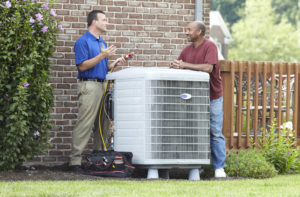 Technician speaking with a man next to a central AC unit