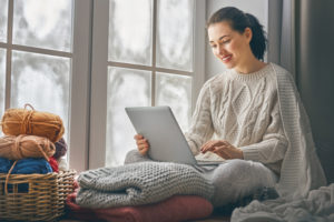 Woman with laptop seated by frosty windows