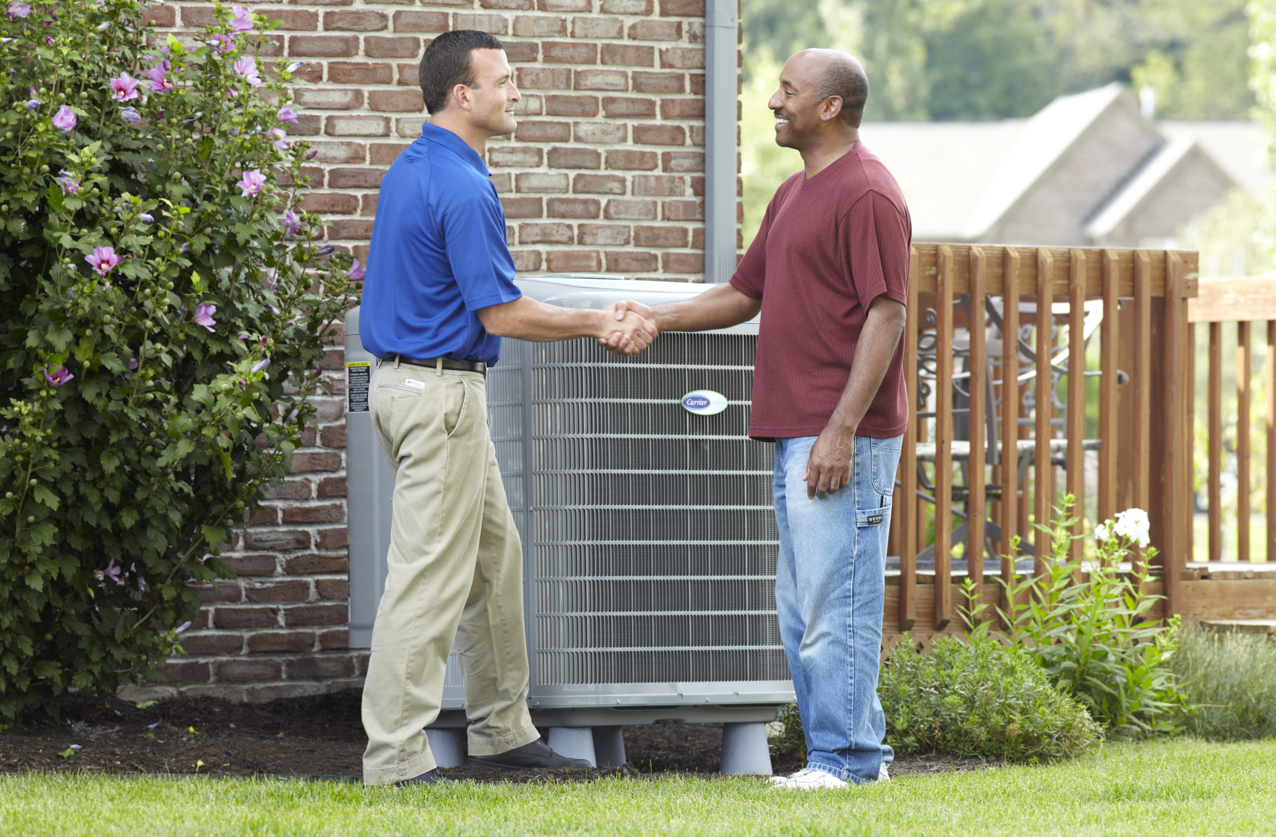 Technician shaking hands with customer after successful AC installation