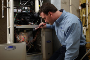 technician inspecting a furnace