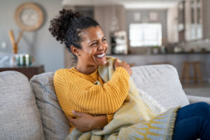 Woman sitting on a couch in a cozy sweater