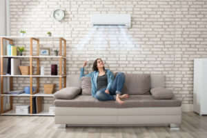 Woman sitting on couch next to a ductless unit