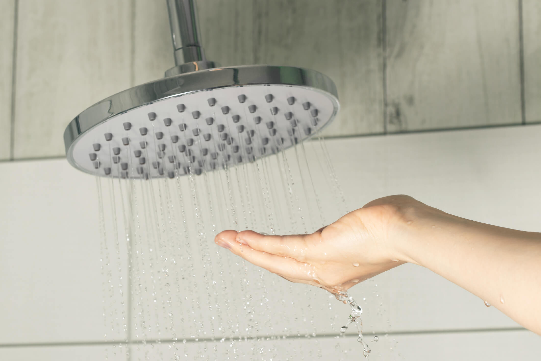 Someone testing the shower water temperature with their hand.
