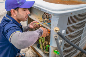 Technician repairing an AC system