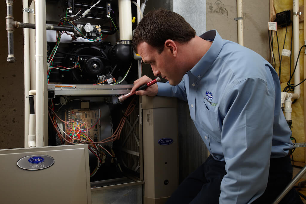 a technician performs furnace maintenance