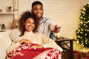 young couple sitting on couch with holiday decorations