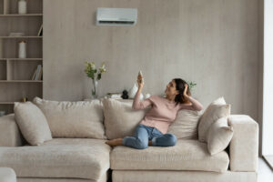 woman lounges on couch using ductless heating