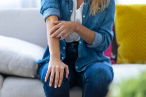 woman itching dry skin at home