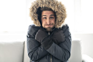 Man on the sofa at home with winter coat