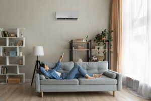 Happy young lady regulate climate at home using ac device