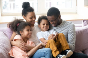 Parents and kids having fun sitting on couch indoors