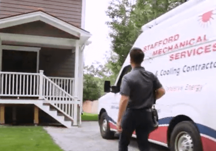 A Stafford Mechanical Technician arrives at a residential job, and approaches the house from his van.