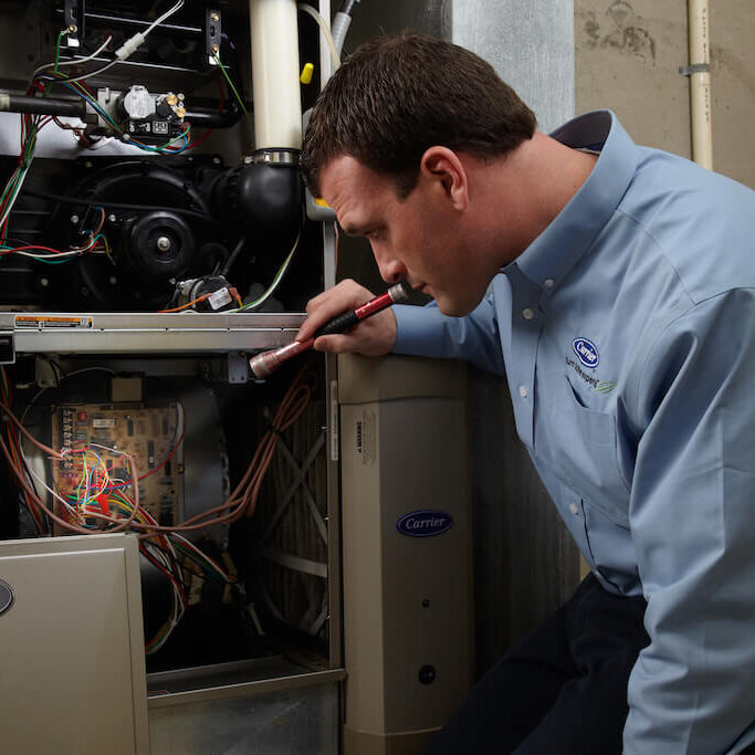 a technician performs furnace maintenance